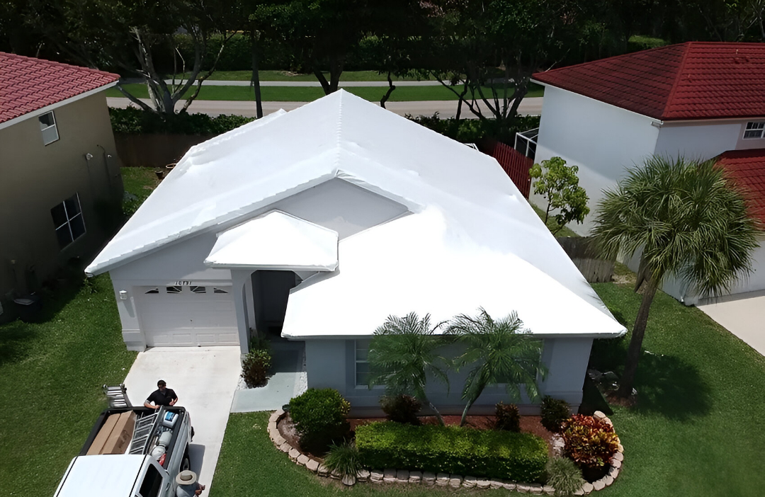 Residential house featuring a white roof under installation or repair, with visible roofing activity by JAC Builders